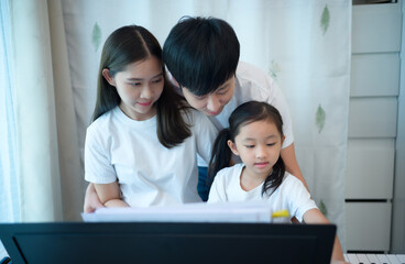 Family vacation, father and mother helping daughter practice in her piano lessons