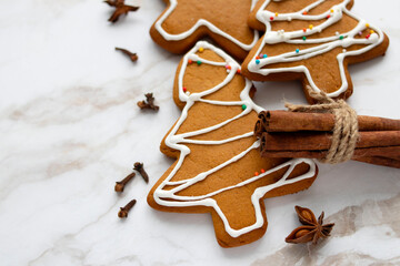 festive gingerbread and spices lie on a light marble background. Top view