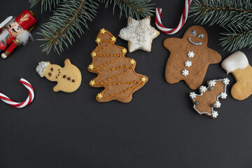 Homemade gingerbread cookies with icing or frosting. Various gingerbreads, decorated Xmas shapes and Christmas tree branches. Holiday Season winter flat lay composition with copy space.