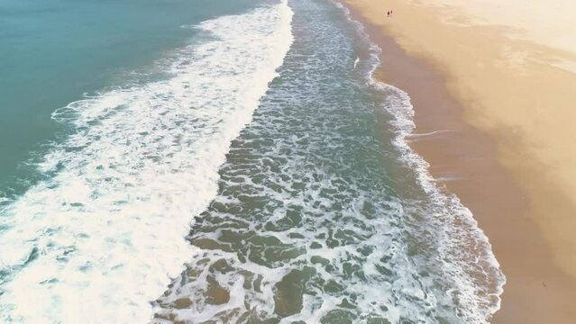 Aerial flying over the crashing waves on the coastline of Los Canos de Meca 