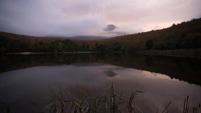 Timelapse of the sunset in the Moncayo mountain, with reflection in the lake, rain and fog. Zaragoza, Spain