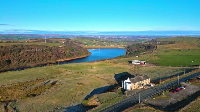 Winter aerial drone footage of  Scammonden Reservoir with the M62 motorway bridge. West Yorkshire, England. With blue water  and blue skys.