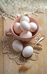 Farm fresh organic large brown eggs in turquoise bowl on rustic wood background. Flat lay composition with room for text and shot in natural light.