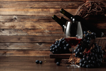 Fototapeta na wymiar Red wine and blue grapes on an old wooden table.