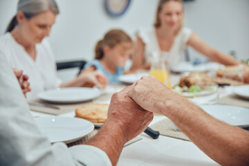 Big family, holding hands and pray before food with love, care and god worship before eating. Buffet, prayer and thanksgiving gratitude with family hands of children, grandparent and mother at home