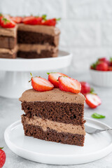 Naked chocolate cake with cream and fresh strawberries on top. Rustic style. Selective focus. Copy space.