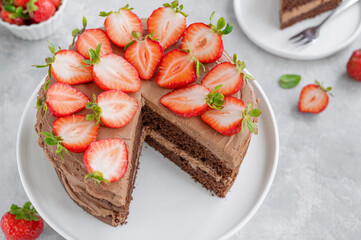 Naked chocolate cake with cream and fresh strawberries on top. Rustic style. Selective focus. Copy space.