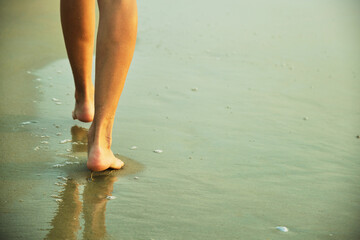 Feet on the beach near the sea.
