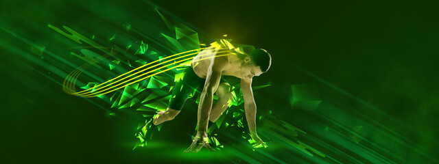 At start. Young muscular athlete, runner or jogger posing over green background neon elements. Concept of sport, healthy lifestyle, motion.