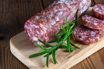 cutting board with sliced salami on it.