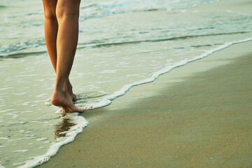 Feet on the beach near the sea.
