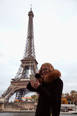 Young lady using smartphone on Paris streets.