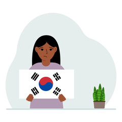 A little girl is holding the flag of South Korea. The concept of demonstration, national holiday, independence day or patriotism. Nationality.