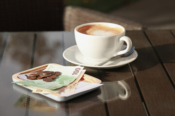 Tasty hot coffee and payment for order on table. Leave tip