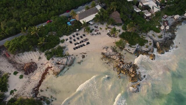 Cinematic aerial reveal of the famous Gitano, a Mexican restaurant situated in the middle of a dense inland jungle and the iconic Tulum Beach on the Caribbean Sea coastline of Mexico
