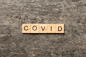 covid word written on wood block. covid text on table, concept