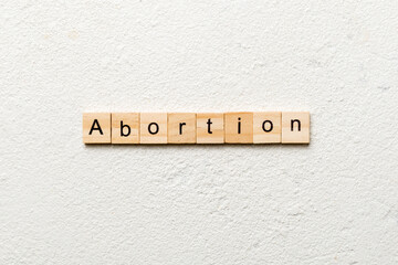 abortion word written on wood block. abortion text on table, concept