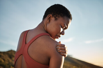 Shoulder, black woman and exercise injury from outdoor sports training on sky background. Athlete,...