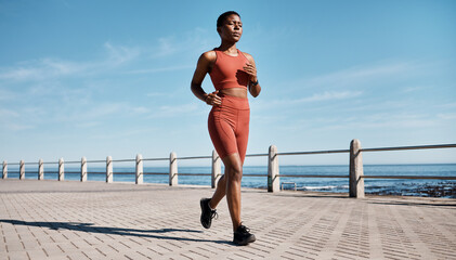 Run, black woman and beach for workout, exercise and training for wellness, health and cardio. African American female, runner and athlete practice, fitness and endurance for marathon, race and ocean