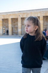 A blond little girl wearing a black sweetshirt is visiting the mausoleum in Ankara. The little girl is sad and grieving for Atatrk. Selective Focus Girls Face.