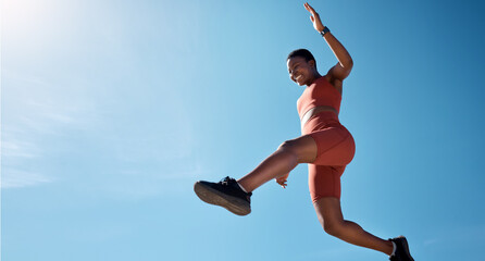 Sports, fitness and black woman jumping with blue sky background from below. Running, exercise and jump, woman training for health goals, motivation and wellness with happy smile and mockup in summer