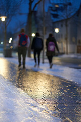 Slippery and icy (Blitzeis, Glatteis) path in the city. 3 boys on the dangerous way to school. In the early winter morning. Germany, Nurtingen.