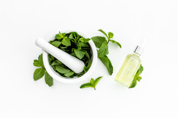 Peppermint essential oil - source of menthol. Mint leaves with bottle of oil