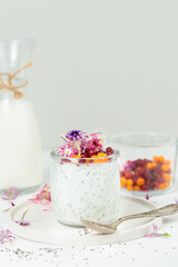 Pudding with chia seeds and edible flowers. Close-up, on a light background, vertical
