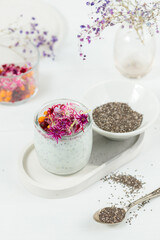 Breakfast, healthy food. Pudding or dessert with chia seeds and edible flowers. Close-up on a white background