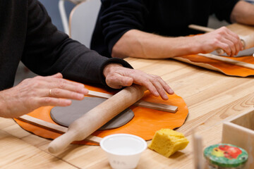 A master pottery craftsman making a small bowl next to a student. Pottery lesson.