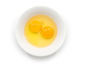Isolated raw chicken eggs, top view of two raw egg yolk in white bowl on white background. - Powered by Adobe