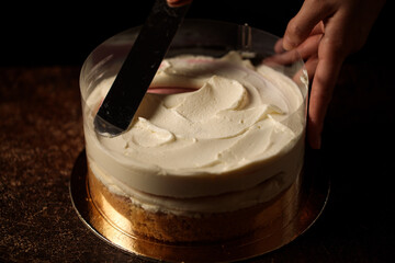 assembling the cake in an acetate film in a dark background cream distribution