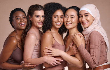 Diversity, women and body positivity for skincare, wellness and solidarity on brown studio background. Multiracial, females, portrait or ladies with smile, confidence or cosmetics for health or relax