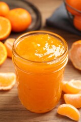 Delicious tangerine jam on wooden table, closeup