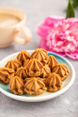 Homemade soft caramel fudge candies on gray concrete, side view, selective focus