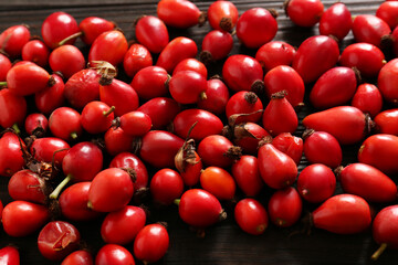 Fresh ripe rosehip berries on wooden table, closeup