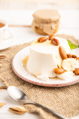 Ricotta cheese with honey and almonds on white wooden. side view, selective focus.
