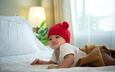 Newborn baby wearing red hats In the white bedroom, warm sunlight in the evening of the day