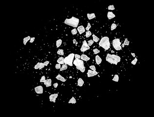 Macro shot of falling and flying salt crystals isolated on black - 555099590
