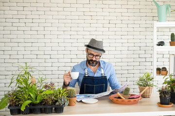 An elderly man handsome with have mustache wearing glasses is happy with tree care. is a hobby of gardening at home, living happily after retirement. Concepts nature and environment