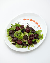 Salad of beetroot, liverwort and lettuce on white plate. Healthy diet. Fitness menu. View from above. Isolate on white background. Copy space