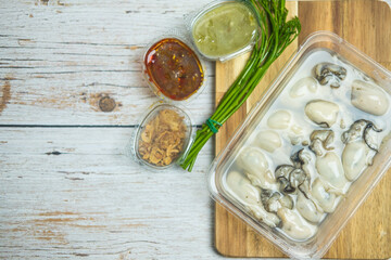 Fresh oyster in box served with fried shallot, chili paste, Acacia Pennata and Thai style seafood sauce
