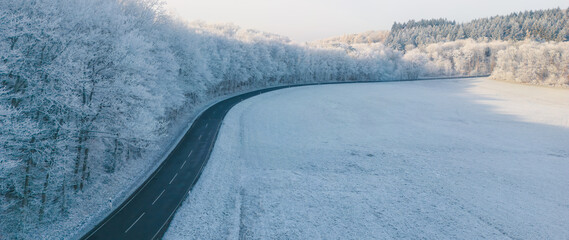 Road going along the forest edge in the beautiful winter landscape