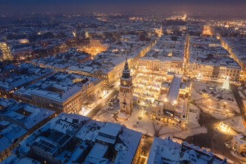 Snow covered old town in Krakow with a view of the Christmas Market photographed in the blue hour.