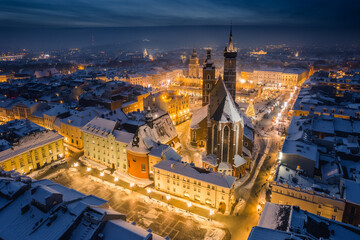 Fototapeta na wymiar Snow covered old town in Krakow with a view of the Christmas Market photographed in the blue hour.