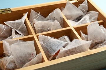 Fototapeta na wymiar Many tea bags in wooden box, closeup