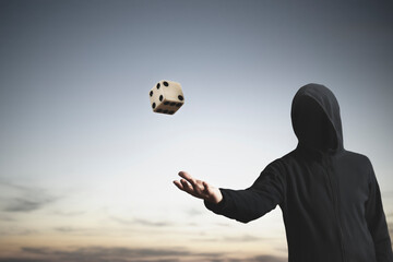 unknown man throws a dice in the air,  a sign of fate and luck