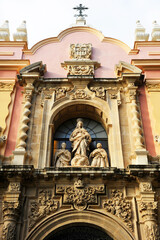 Fototapeta premium Sculptural group with the Virgin Mary on the main facade of the former convent of La Merced, now the Museum of Fine Arts in Seville, Andalusia Spain. Baroque architecture of Seville