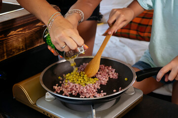 The mother prepares the food on a wonderful day at camp. Van life concept.