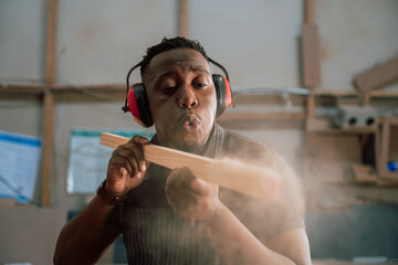 Young African carpenter wood working in factory